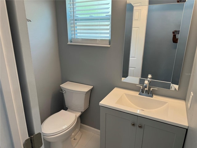 half bath with vanity, baseboards, tile patterned flooring, and toilet