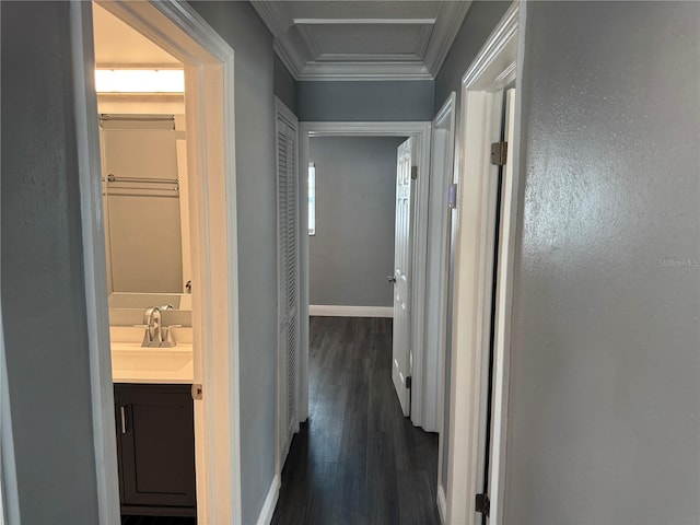hallway featuring ornamental molding, baseboards, attic access, dark wood-style floors, and a sink