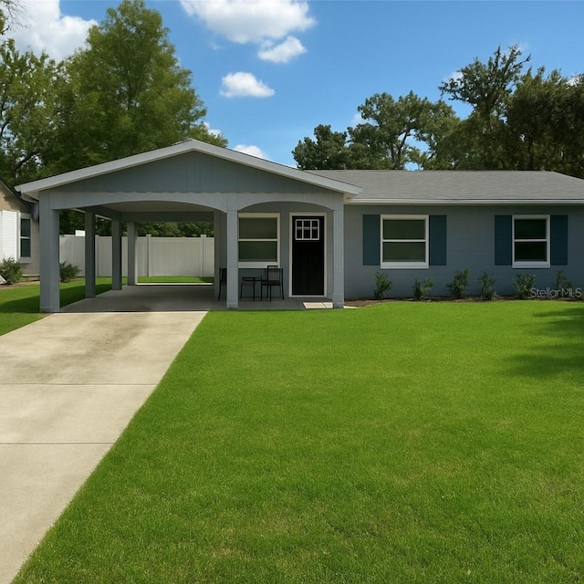 2205 N Grady Ave, Tampa, FL 33607 - ranch-style house featuring fence, driveway, a front yard, and a carport
