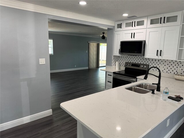 2205 N Grady Ave, Tampa, FL 33607 - kitchen with crown molding, baseboards, stainless steel appliances, and white cabinetry