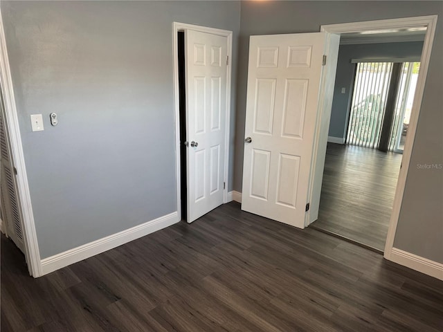 2205 N Grady Ave, Tampa, FL 33607 - unfurnished bedroom featuring dark wood-style flooring and baseboards