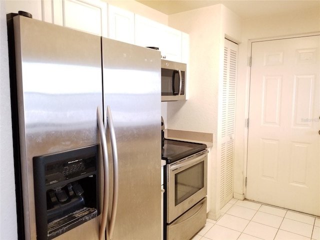kitchen featuring light tile patterned floors, white cabinets, and appliances with stainless steel finishes