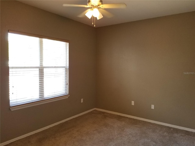 empty room featuring carpet, a ceiling fan, and baseboards