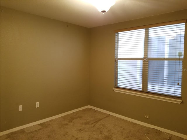 spare room with baseboards, a healthy amount of sunlight, and carpet floors