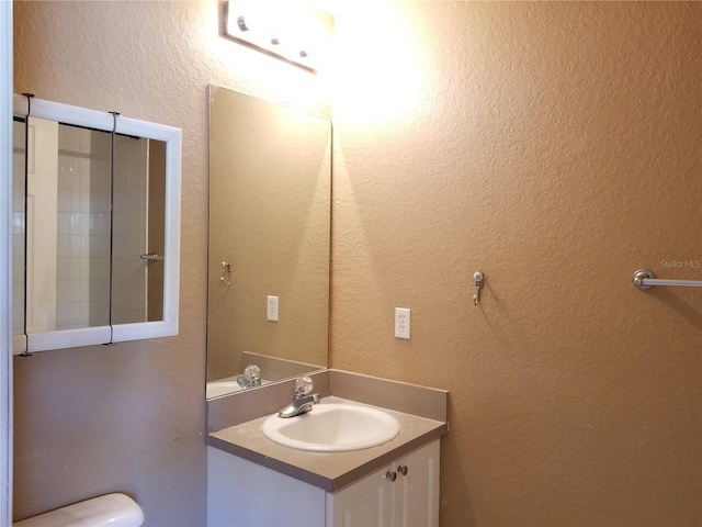 bathroom featuring a textured wall and vanity