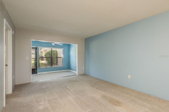 carpeted spare room with ceiling fan and a textured ceiling