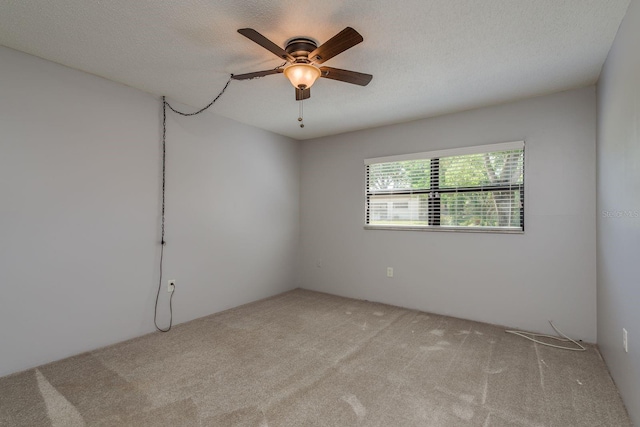 spare room with a ceiling fan, a textured ceiling, and carpet