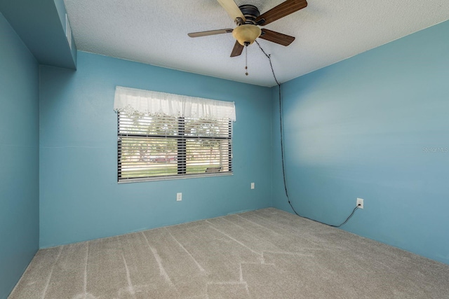 carpeted empty room featuring a textured ceiling and ceiling fan