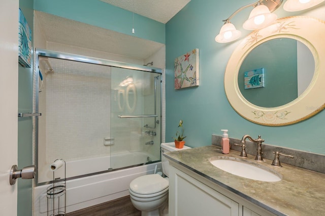 full bath featuring toilet, bath / shower combo with glass door, wood finished floors, and vanity
