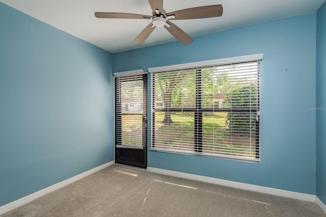 empty room with baseboards, a ceiling fan, and carpet floors