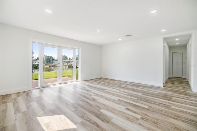 empty room featuring recessed lighting, visible vents, light wood-style flooring, and baseboards