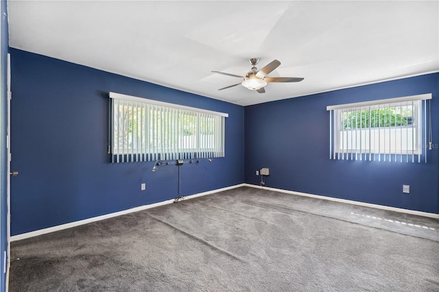 carpeted spare room with baseboards and ceiling fan