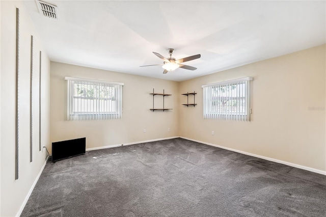 carpeted spare room with visible vents, baseboards, and ceiling fan