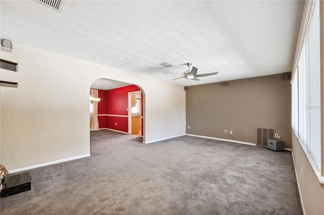 spare room featuring visible vents, arched walkways, ceiling fan, and carpet floors