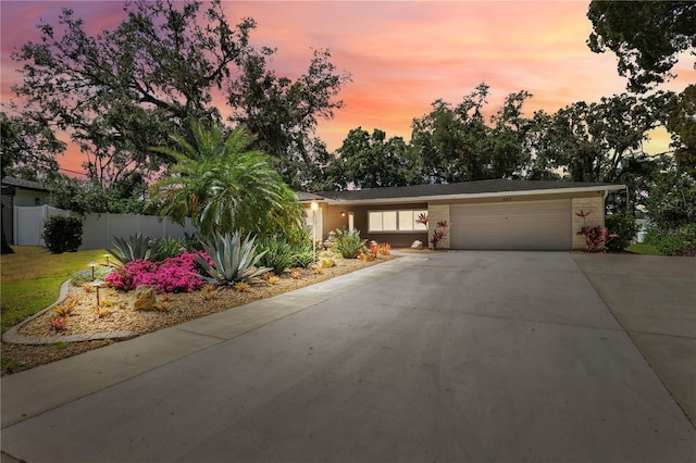 view of front of house featuring fence, an attached garage, concrete driveway, and brick siding