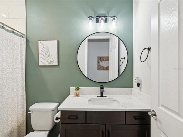 bathroom with toilet, a shower with curtain, and vanity