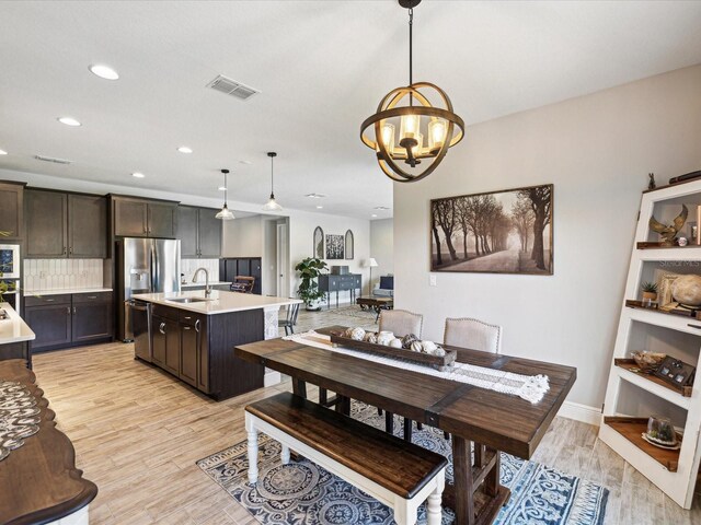dining room featuring an inviting chandelier, recessed lighting, light wood-style flooring, and visible vents