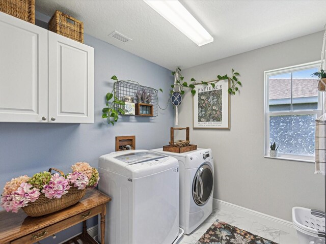clothes washing area featuring visible vents, marble finish floor, baseboards, separate washer and dryer, and cabinet space