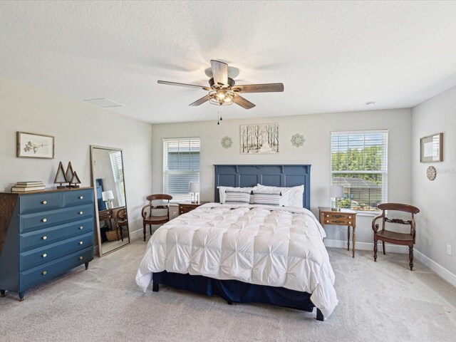 bedroom featuring a ceiling fan, multiple windows, and light carpet