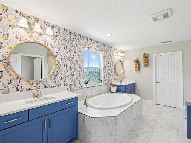 full bath with a garden tub, a sink, two vanities, and visible vents