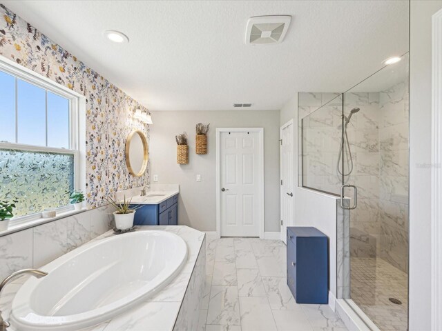 full bathroom featuring a garden tub, a textured ceiling, a shower stall, vanity, and marble finish floor