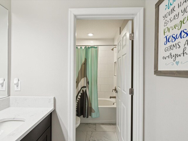 full bath featuring vanity, marble finish floor, toilet, baseboards, and shower / bath combo