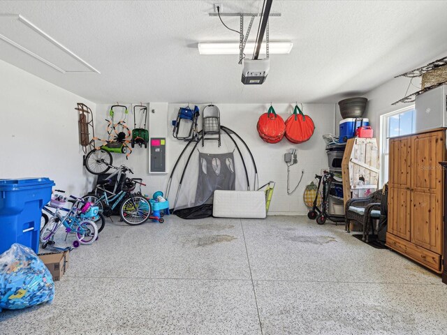 garage with a garage door opener and electric panel