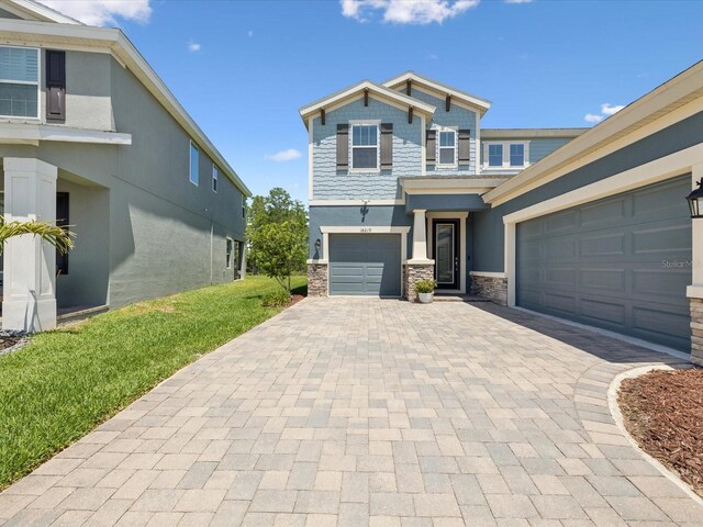 view of front facade with decorative driveway, stucco siding, and stone siding