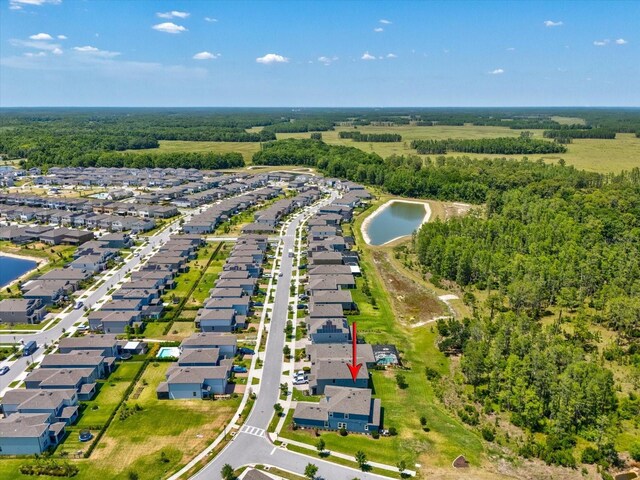 bird's eye view with a water view, a view of trees, and a residential view
