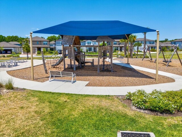 communal playground featuring a residential view and a lawn