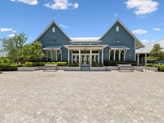 rear view of house featuring french doors, a standing seam roof, and metal roof