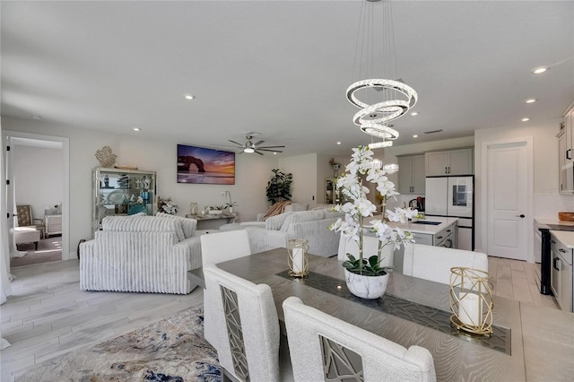 6252 Hidden Branch Dr, Apollo Beach, FL 33572 - dining space featuring recessed lighting, light wood-style flooring, and ceiling fan with notable chandelier