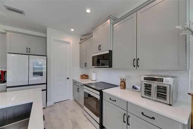 6252 Hidden Branch Dr, Apollo Beach, FL 33572 - kitchen with visible vents, freestanding refrigerator, electric range oven, stainless steel microwave, and gray cabinets
