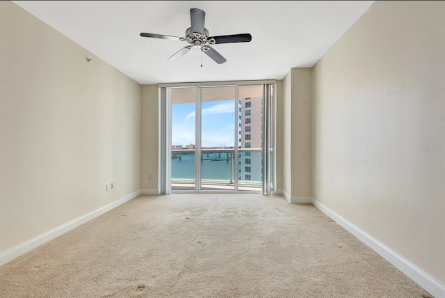 241 Riverside Dr Unit 1107, Daytona Beach, FL 32117 - unfurnished room featuring ceiling fan, a water view, baseboards, floor to ceiling windows, and carpet