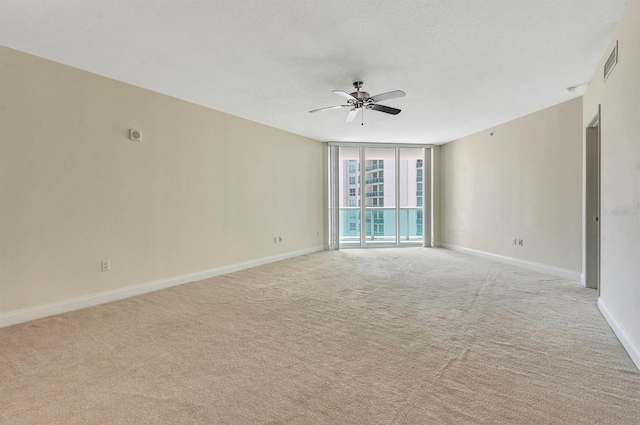 241 Riverside Dr Unit 1107, Daytona Beach, FL 32117 - empty room with baseboards, visible vents, light colored carpet, and expansive windows