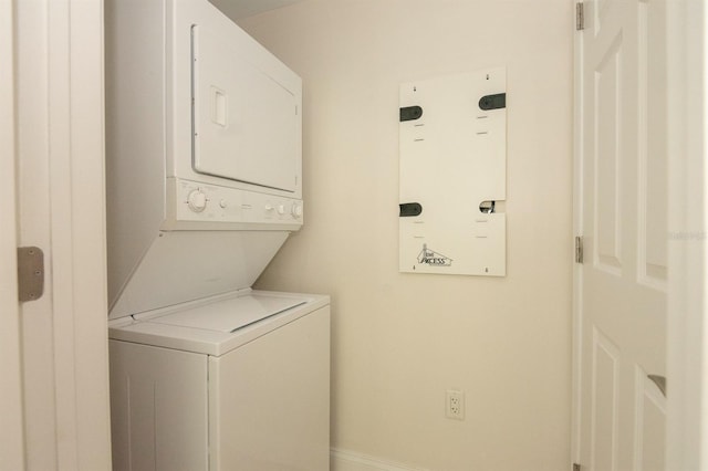 241 Riverside Dr Unit 1107, Daytona Beach, FL 32117 - washroom featuring stacked washer and dryer, laundry area, and baseboards