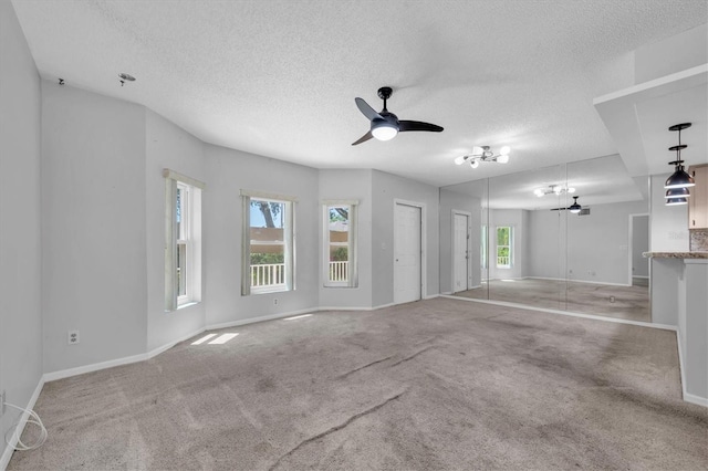 2231 Utopian Dr E Unit 117, Clearwater, FL 33763 - unfurnished living room with plenty of natural light, ceiling fan, a textured ceiling, and baseboards