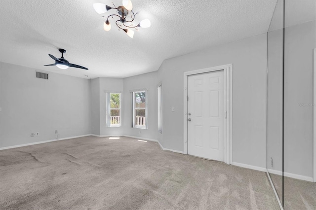2231 Utopian Dr E Unit 117, Clearwater, FL 33763 - unfurnished room with a textured ceiling, carpet floors, baseboards, a chandelier, and a ceiling fan