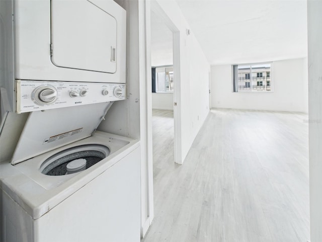 201 W Laurel St Unit 504B, Tampa, FL 33602 - clothes washing area with stacked washing machine and dryer and light wood-style floors