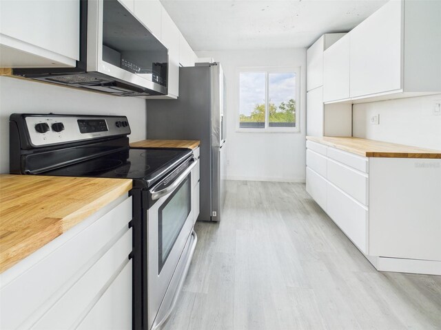 201 W Laurel St Unit 504B, Tampa, FL 33602 - kitchen with appliances with stainless steel finishes, wood counters, light wood-style floors, white cabinetry, and modern cabinets