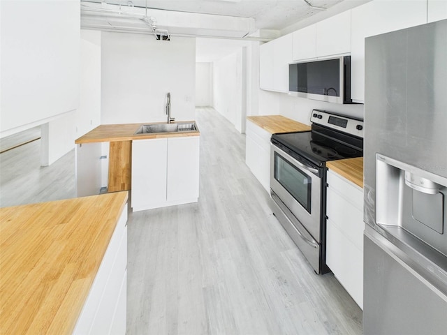 201 W Laurel St Unit 504B, Tampa, FL 33602 - kitchen with appliances with stainless steel finishes, a sink, butcher block countertops, white cabinetry, and modern cabinets