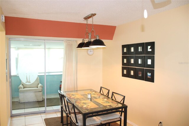 9950 47th Ave N Unit 311, Saint Petersburg, FL 33708 - dining room featuring tile patterned flooring, vaulted ceiling, and a textured ceiling