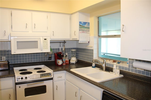 9950 47th Ave N Unit 311, Saint Petersburg, FL 33708 - kitchen with a sink, tasteful backsplash, white cabinetry, white appliances, and dark countertops