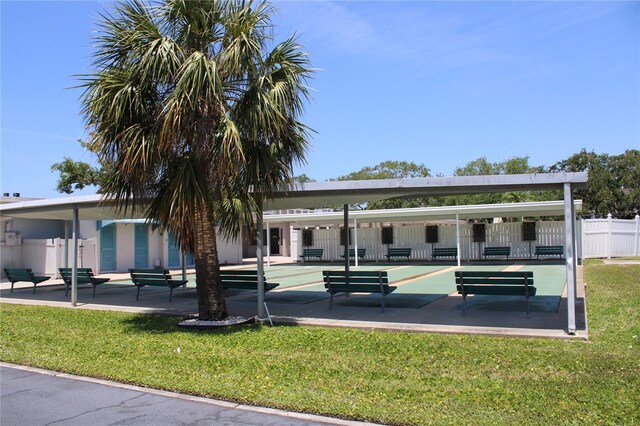 9950 47th Ave N Unit 311, Saint Petersburg, FL 33708 - view of community with fence, a lawn, and shuffleboard