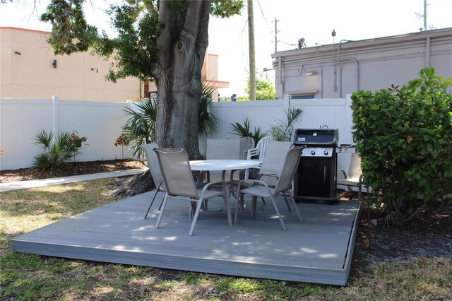 9950 47th Ave N Unit 311, Saint Petersburg, FL 33708 - view of patio with a wooden deck, a fenced backyard, area for grilling, and outdoor dining area