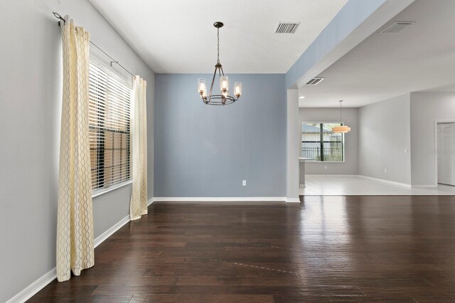 19407 Sweet Grass Way, Lutz, FL 33558 - unfurnished room with an inviting chandelier, visible vents, wood finished floors, and baseboards