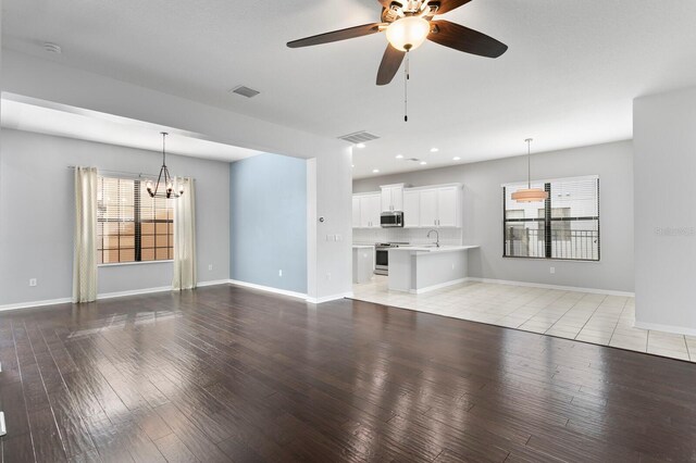 19407 Sweet Grass Way, Lutz, FL 33558 - unfurnished living room featuring visible vents, a healthy amount of sunlight, and light wood-style floors