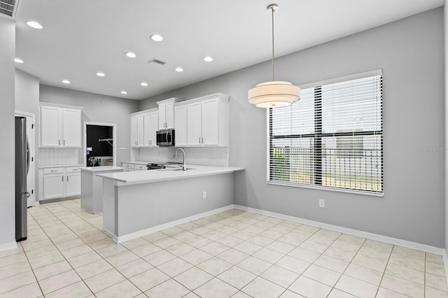 19407 Sweet Grass Way, Lutz, FL 33558 - kitchen featuring decorative backsplash, a sink, stainless steel appliances, light countertops, and a peninsula
