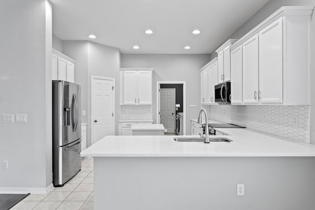 19407 Sweet Grass Way, Lutz, FL 33558 - kitchen featuring recessed lighting, a sink, a peninsula, washer and dryer, and appliances with stainless steel finishes