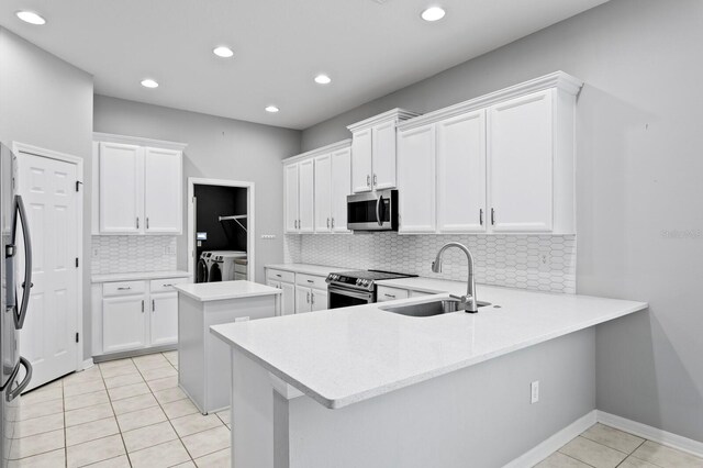 19407 Sweet Grass Way, Lutz, FL 33558 - kitchen with a sink, stainless steel appliances, washer and clothes dryer, light tile patterned floors, and backsplash